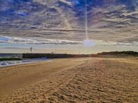 Golden beach with lighthouse at sunset 